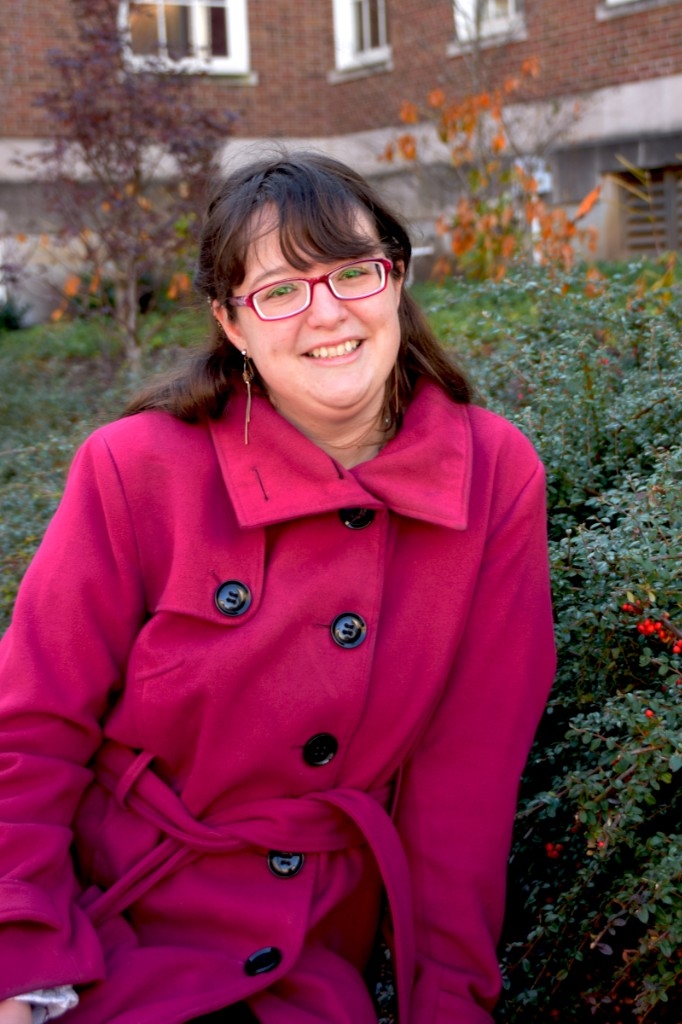 Abigail Richard poses outside in a magenta winter coat.
