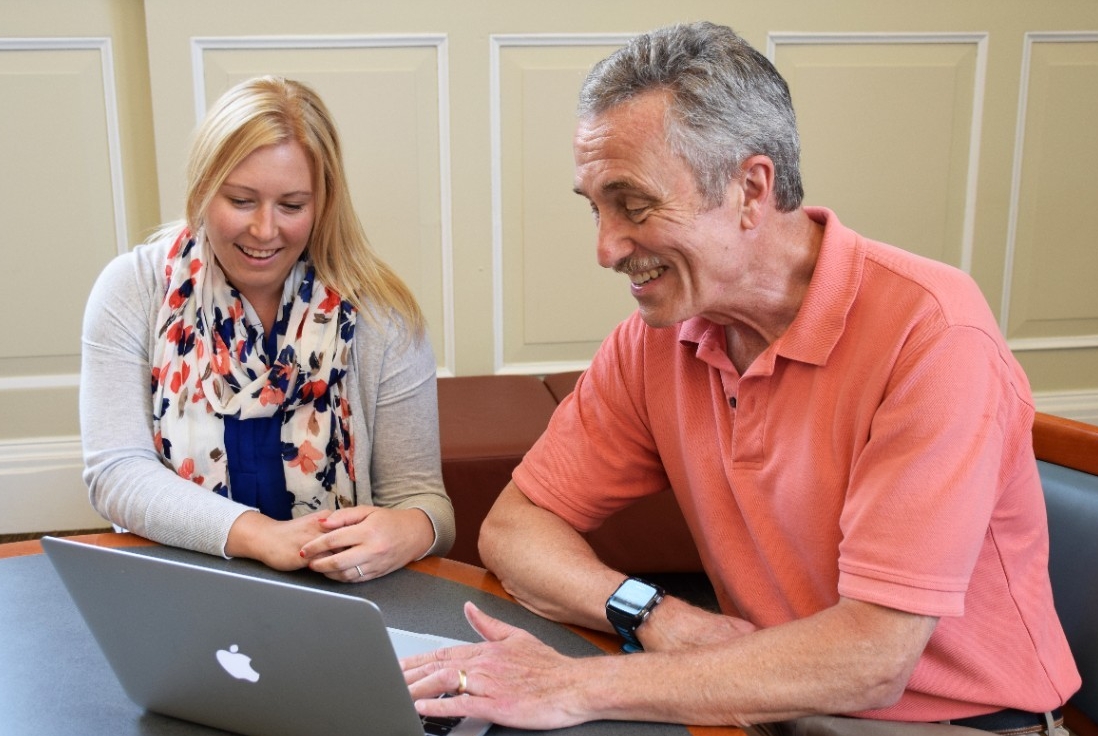 A graduate student works with her faculty mentor at a computer.
